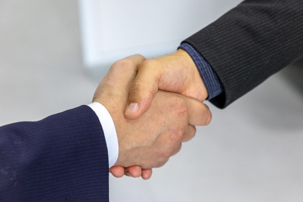 Nahaufnahme zweier Geschäftsleute, die sich die Hände schütteln – ein Symbol für Einigung und Partnerschaft.